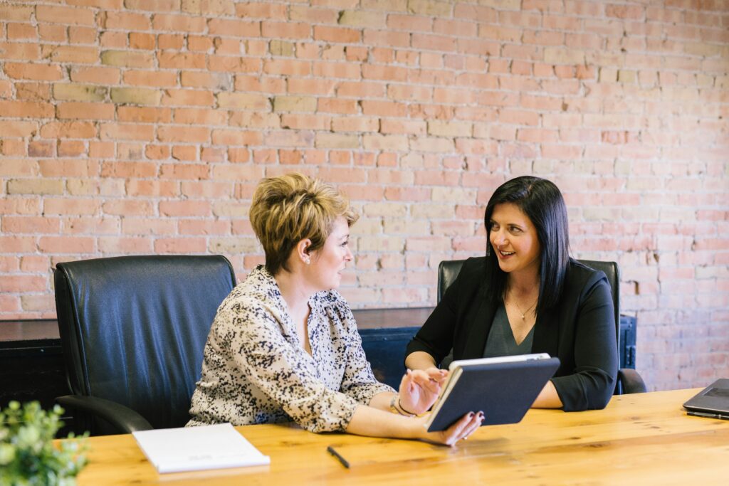 Two professional women discussing Employer of Record solutions